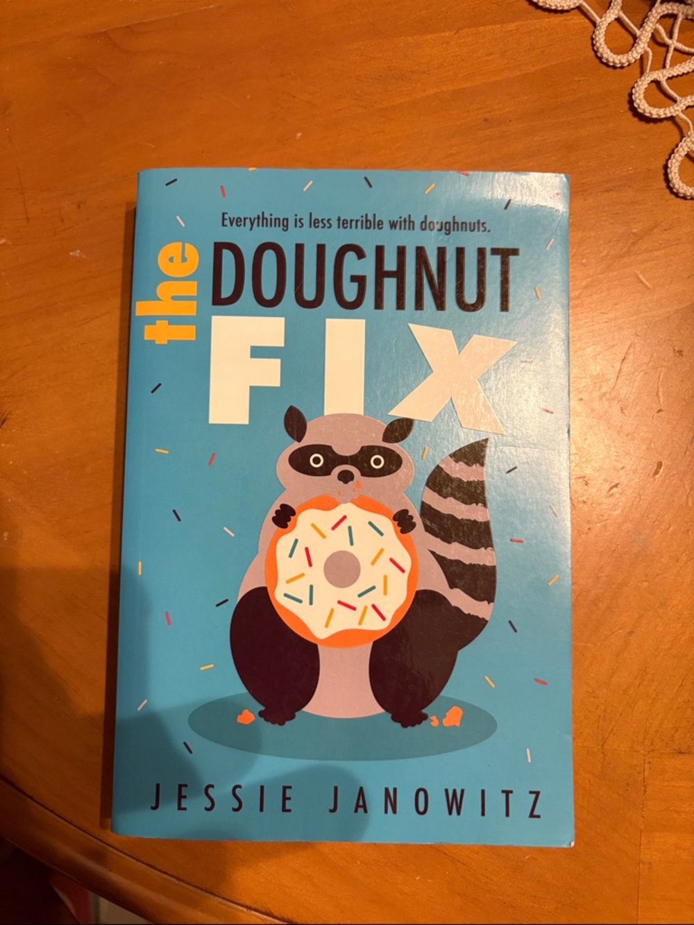 The Doughnut Fix by Jessie Janowitz - Bright Blue Cover with Raccoon & Donut